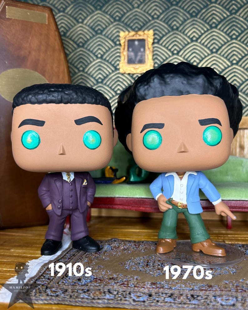 May include: Two vinyl figures with large heads and glowing green eyes. The left figure wears a dark purple suit, while the right figure wears a light blue blazer, white shirt, and green trousers. Text below reads 1910s and 1970s respectively.
