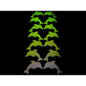 以下が含まれることがあります： 黒い背景に、緑と白の様々な色合いのイルカの形をしたステッカーのコレクションが、縦の列に並んでいます。ステッカーは反射性があり、キラキラした外観をしています。