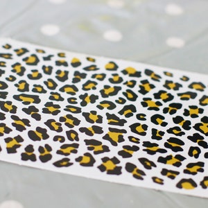 Folha de vinil autoadesiva com estampa de leopardo.
