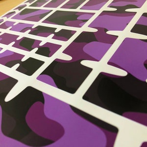 Puede incluir: Hoja de pegatinas para teclado de camuflaje morado y negro con recortes blancos para cada tecla.