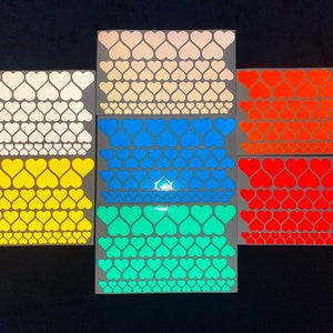 May include: Six sheets of heart-shaped stickers in various colors, including white, yellow, blue, red, and turquoise. Each sheet has a grid of hearts.
