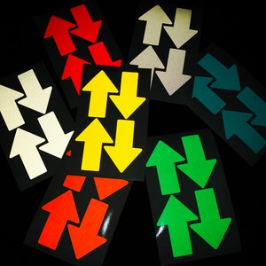May include: Assortment of eight arrow stickers in various colors, including red, yellow, silver, teal, and green. Each sticker features two arrows pointing in opposite directions.