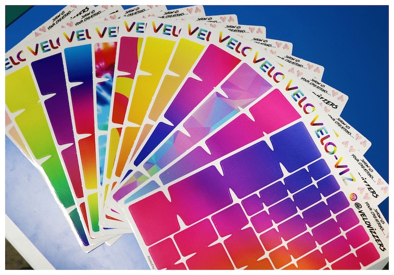 May include: A set of colorful, gradient patterned stickers with the text "Show us your creations... #VELOVIZERS @VELOVIZERS" printed on each sticker.