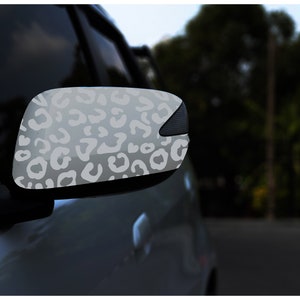 Könnte beinhalten: Ein Auto-Seitenspiegel mit einem weißen Leopardenmuster.