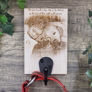 May include: A wooden sign with a laser-engraved image of a child and a dog. The sign has a black metal hook and the text "The bond with a true dog is as lasting as the ties of this earth will ever be".