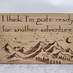 May include: Wooden sign with the text "I think I'm quite ready for another adventure!" and a mountain range with stars and a crescent moon in the background.