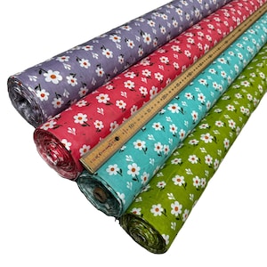 May include: Four rolls of fabric with a white daisy print on a variety of colored backgrounds: purple, pink, turquoise, and green.