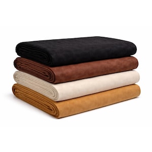 May include: Four fabric samples in a stack, each in a different colour. The top one is black, followed by brown, cream, and a golden-yellow shade. The fabrics are neatly folded, displaying a smooth, textured surface. The samples are stacked on top of each other.