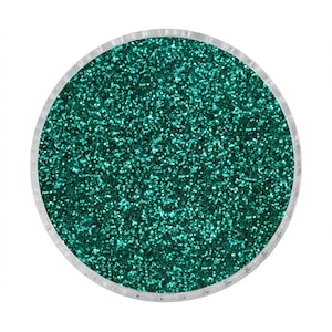 May include: A round container filled with teal green glitter.