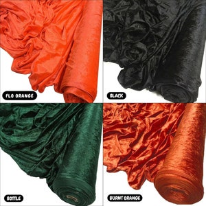 May include: Four fabric swatches of velvet in different colours: burnt orange, black, bottle green, and flo orange. The fabric is rolled up and the ends are visible.