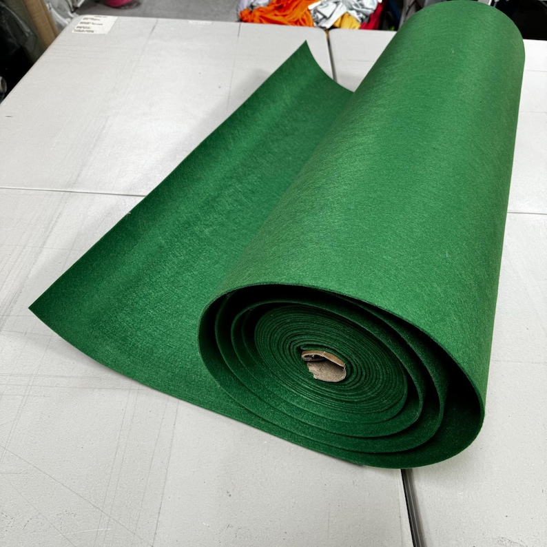 Puede incluir: Un rollo de tela de fieltro verde. El fieltro est&aacute; enrollado apretado y listo para ser usado en proyectos de manualidades.
