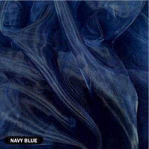 May include: Navy blue sheer fabric with a smooth, silky texture. The fabric is draped and folded, showcasing its translucent quality.