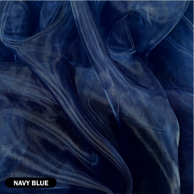 May include: Navy blue sheer fabric with a smooth, silky texture. The fabric is draped and folded, showcasing its translucent quality.