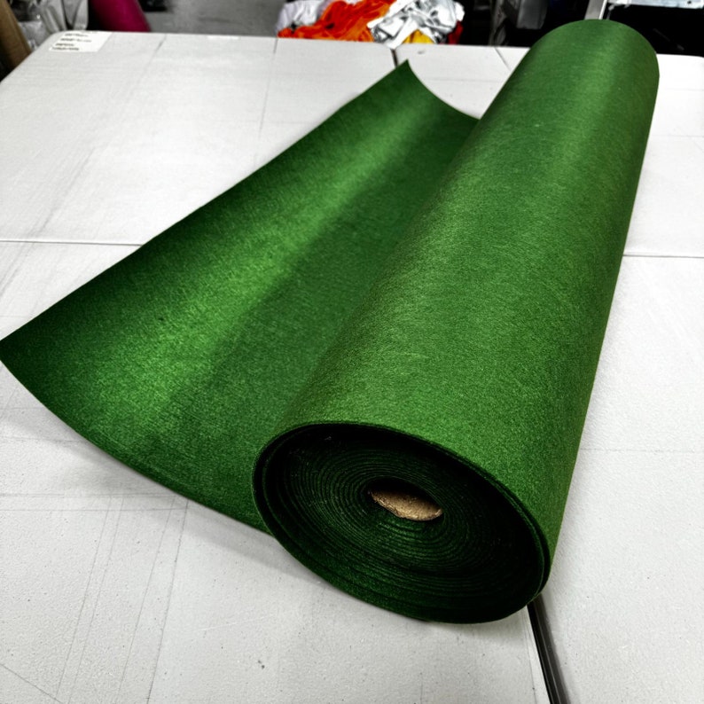 Puede incluir: Un rollo de tela de fieltro verde. La tela est&aacute; enrollada y el extremo est&aacute; doblado. La tela es de color verde oscuro.