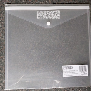 May include: Clear plastic envelope with a white flap and a button closure. The envelope is labeled "Envelope for Stamps" and "Iron Orchid Designs".