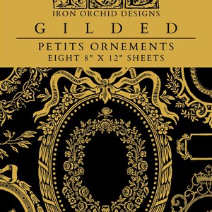 May include: Eight 8-inch by 12-inch sheets of decorative paper with gold-colored ornate designs on a black background. The paper is titled "Gilded Petits Ornements" and is from Iron Orchid Designs.