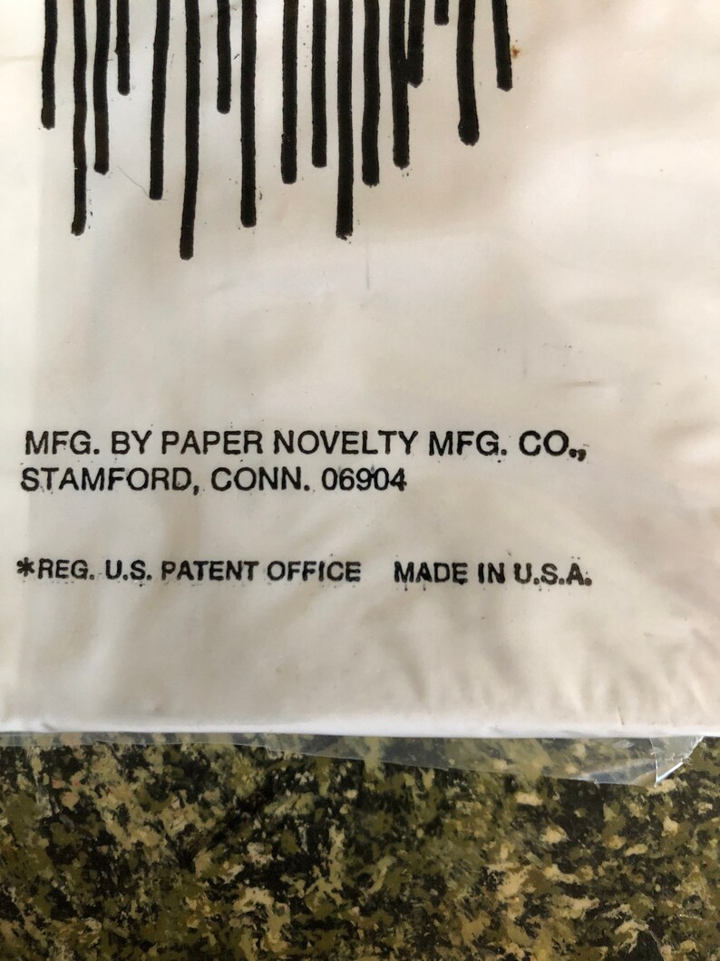 May include: Close-up of a white surface with black vertical lines at the top. Text includes "MFG. BY PAPER NOVELTY MFG. CO., STAMFORD, CONN. 06904" and "*REG. U.S. PATENT OFFICE MADE IN U.S.A."