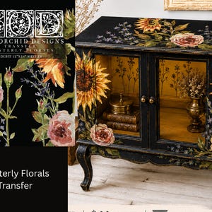 May include: A black cabinet decorated with Iron Orchid Designs Painterly Florals transfer featuring sunflowers and roses. The cabinet has two glass doors, gold interior, and curved legs. The transfer packaging shows eight 12x16 inch sheets.