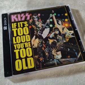 Könnte beinhalten: Eine CD-Hülle der Band KISS mit dem Album "If It's Too Loud, You're Too Old". Das Cover zeigt die Bandmitglieder in voller Maske und Bühnenoutfit, die Gitarre spielen. Die Hülle ist mit "2 Discs" beschriftet.