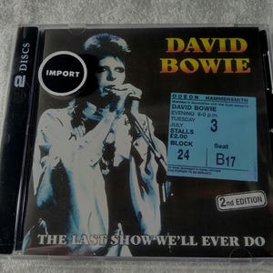 May include: A David Bowie CD case featuring a black and white image of the artist singing into a microphone. The CD case includes the text "DAVID BOWIE" in gold letters, a concert ticket, and the text "THE LAST SHOW WE'LL EVER DO."
