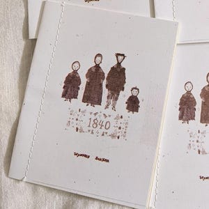 May include: Four off-white notebooks with a brown illustration of a family and the year 1840. The notebooks have a stitched binding and the text "Wynifred Saxner" at the bottom.