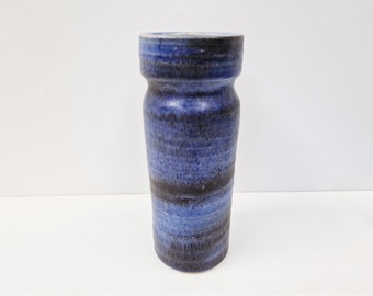 May include: A blue and black ceramic vase with a textured finish. The vase has a cylindrical shape with a slightly wider opening at the top.