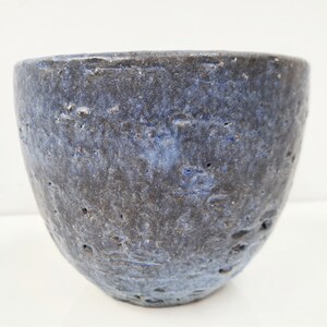 Könnte beinhalten: Eine blaue Keramikschüssel mit strukturierter Oberfläche. Die Schüssel ist rund und hat eine breite Öffnung.