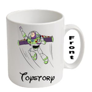 Puede incluir: Taza de cerámica blanca con una ilustración de dibujos animados de Buzz Lightyear de Toy Story. El personaje está representado con su traje espacial y alas. La taza tiene la palabra "Toy Story" en una fuente de escritura. La palabra "Front" está impresa en el asa.