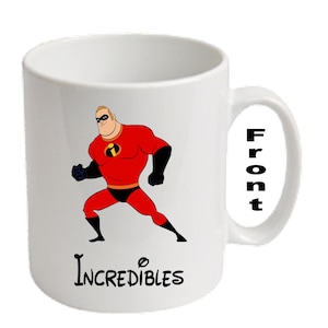 Könnte beinhalten: Weiße Keramik-Tasse mit einem Cartoon-Bild von Mr. Incredible aus Die Unglaublichen. Die Figur ist in einer dynamischen Pose, trägt einen roten Anzug mit schwarzen Akzenten. Das Wort "Incredibles" steht darunter.