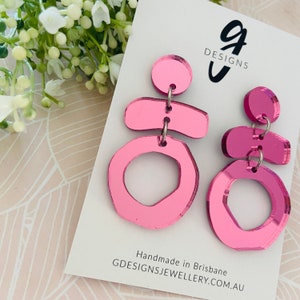 Könnte beinhalten: Rosa geometrisch geformte Ohrringe mit einer verspiegelten Oberfläche. Die Ohrringe sind handgefertigt in Brisbane, Australien. GDESIGNSJEWELLERY.COM.AU