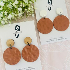 Könnte beinhalten: Ein Paar braune und weiße Statement-Ohrringe mit einem strukturierten runden Design. Die Ohrringe sind handgefertigt in Brisbane, Australien. GDesignsJewellery.com.au