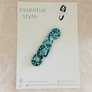 May include: Teal blue glitter mask extender with a unique design.  The extender is made of a durable material and is easy to use.  Essential Style g Designs.