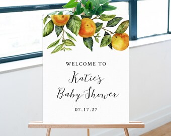 May include: Welcome to Katie's Baby Shower sign featuring a watercolour illustration of orange blossoms and leaves. The date 07.17.27 is printed below the text.