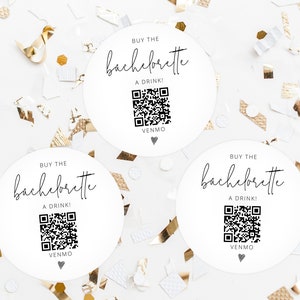 May include: Three white round stickers with black text that says "Buy the Bachelorette a Drink!" and a black and white QR code. The text "Venmo" is also on the stickers.