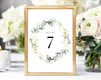 May include: A gold-framed table number card with a white floral wreath and the text "Table No. 7".