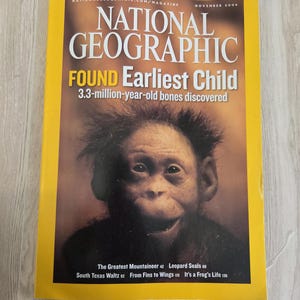 May include: A November 2006 National Geographic magazine with a yellow border. The cover features a primate and the text: FOUND Earliest Child, 3.3-million-year-old bones discovered, The Greatest Mountaineer 42, Leopard Seals 68, South Texas Waltz 92.
