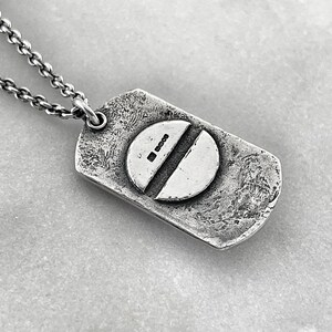 back of dog tag showing a screw head with thejewel thief brighton hallmark