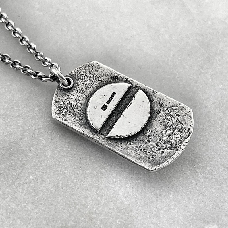 back of dog tag showing a screw head with thejewel thief brighton hallmark