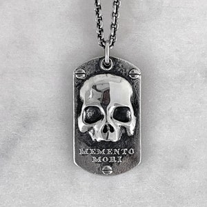 front shot of dog tag with a skull and memento mori made by jewel thief brighton