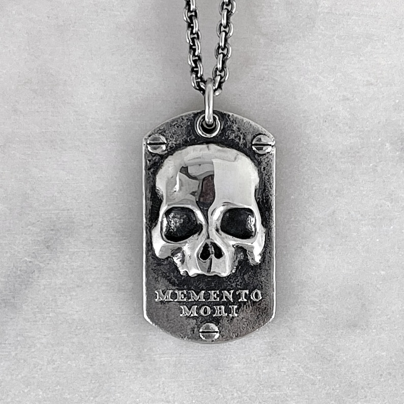 front shot of dog tag with a skull and memento mori made by jewel thief brighton