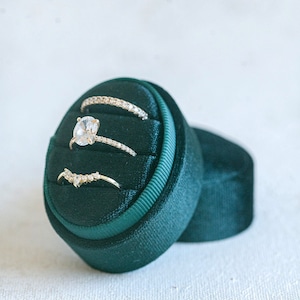 May include: Three gold rings with diamonds set in a dark green velvet ring box.