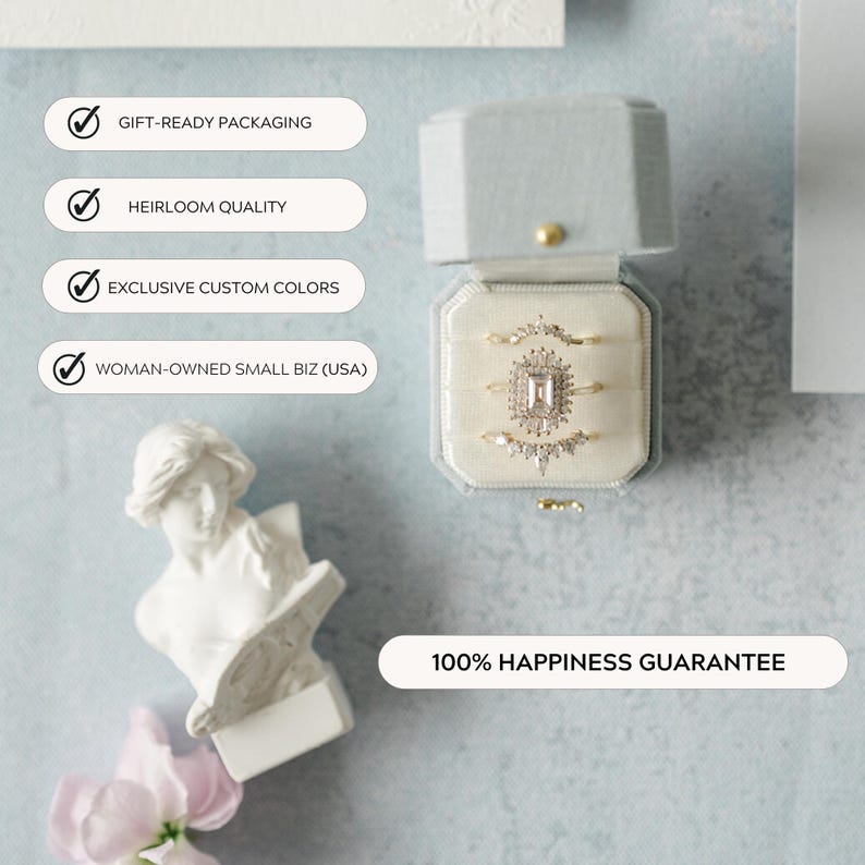 May include: A light blue velvet ring box displaying three gold rings. The rings feature a central stone and surrounding smaller stones. The box is open, revealing a cream-coloured interior. Text on the image reads: Gift-Ready Packaging, Heirloom Quality, Exclusive Custom Colors, Woman-Owned Small Biz (USA), and 100% Happiness Guarantee.