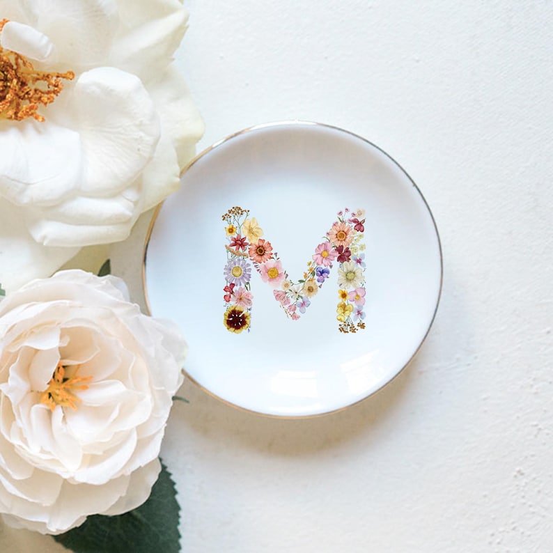 gift-ready personalized ring dish with gold trim, wedding and bridal shower gift idea, handcrafted ceramic ring dish made in small Northern California studio, floral initial jewelry tray, birth flower, birthflower, ceramic jewelry holder with gold trim and floral initial, personalized trinket dish for dresser or nightstand, smooth white ceramic ring dish with gold rim, high-quality bridal jewelry tray