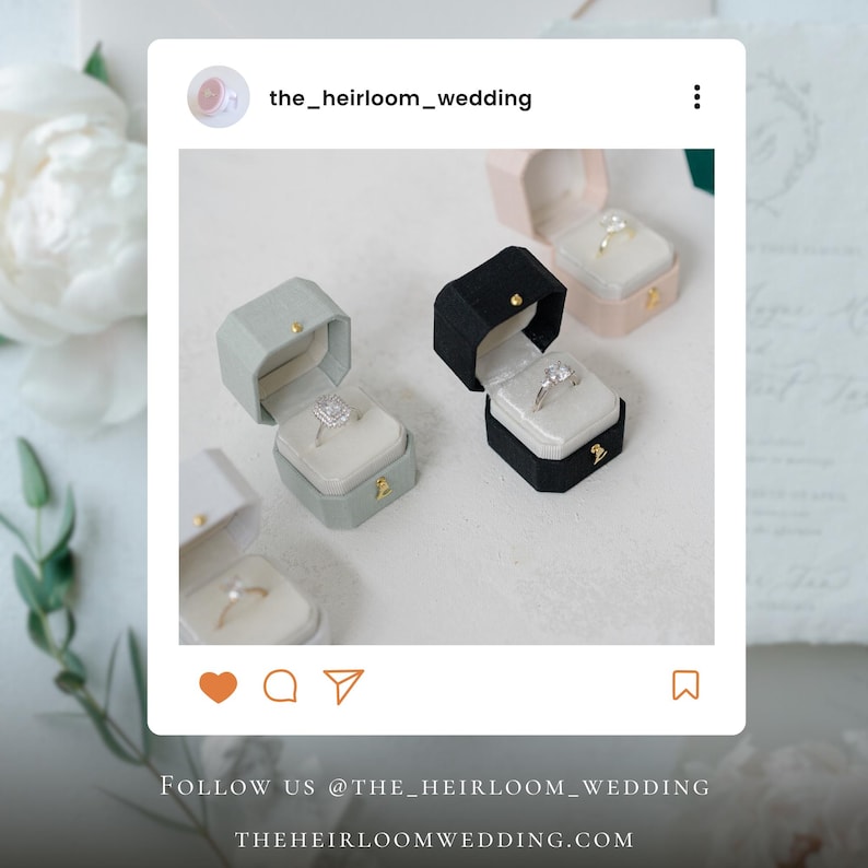 Op de afbeelding: Verschillende open ringdozen in diverse kleuren, waaronder grijs, zwart en roze, elk met een diamanten ring. De dozen zijn geplaatst op een witte ondergrond. De tekst "FOLLOW US @THE_HEIRLOOM_WEDDING" en "THEHEIRLOOMWEDDING.COM" zijn zichtbaar.