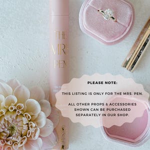 K&ouml;nnte beinhalten: Eine rosa Flasche mit dem Text "THE MRS. PEN" darauf. Die Flasche steht auf einer wei&szlig;en Oberfl&auml;che. Der Text "PLEASE NOTE: THIS LISTING IS ONLY FOR THE MRS. PEN. ALL OTHER PROPS & ACCESSORIES SHOWN CAN BE PURCHASED SEPARATELY IN OUR SHOP." ist in einem wei&szlig;en Kreis auf rosa Hintergrund geschrieben.
