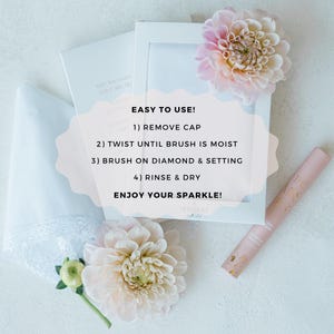 K&ouml;nnte beinhalten: Eine wei&szlig;e Box mit dem Text "EASY TO USE!" und Anweisungen zur Verwendung einer Diamantenreinigungsb&uuml;rste. Die Box steht auf einer wei&szlig;en Oberfl&auml;che mit einer rosa Blume und einer Flasche Diamantenreinigungsl&ouml;sung.
