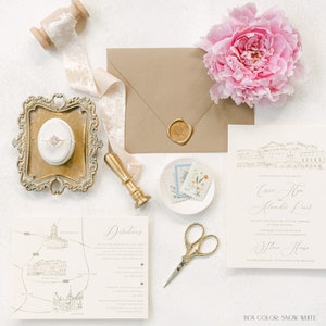 May include: A wedding invitation suite with a white background. The invitation features a gold wax seal and a hand-drawn illustration of a building. The invitation text reads "Celebrating with style and beauty,  Cassa and Alex,  Alexander Lind, Request the pleasure of your company at their wedding, Saturday the 12th of June, Two o'clock in the afternoon, The House, Buckingham, United Kingdom, WR18 2GZ, BOX COLOR: SNOW WHITE".