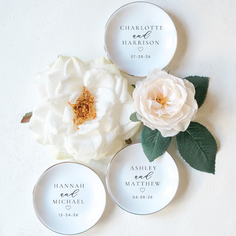 Custom ring dish with gold trim and initials — personalized bridal shower gift and elegant wedding accessory.”

“Engagement ring trinket tray with initials and date — custom wedding décor and keepsake dish for rings.”

“Round ceramic jewelry dish personalized for brides, bridesmaids, and newly engaged couples — engagement gift idea.”

“Custom engagement ring holder with monogram — personalized wedding gift and jewelry organizer.”