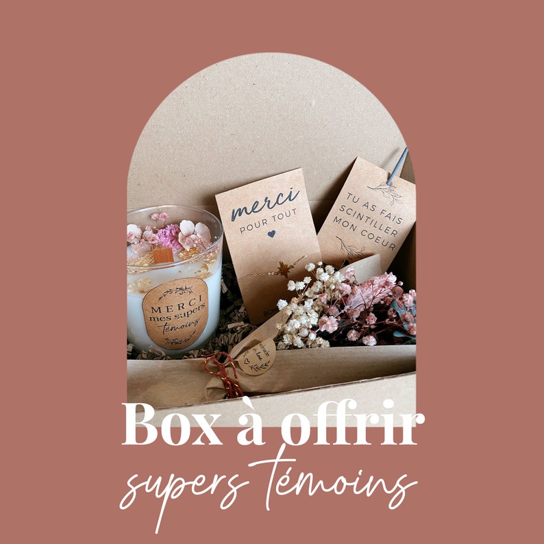 May include: A brown cardboard box filled with gifts for a special occasion. The box contains a candle with a white label that says "MERCI mes supers t&eacute;moins", a small card that says "merci pour tout", a small card that says "TU AS FAIS SCINTILLER MON COEUR", and a bouquet of dried flowers. The box is labeled "Box &agrave; offrir supers t&eacute;moins".