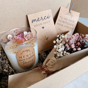 May include: A gift box filled with a white candle with dried flowers and gold flakes, a gold star necklace, a small bouquet of dried flowers, and three cards with the text "merci pour tout", "tu as fais scintiller mon coeur", and "handmade with love".